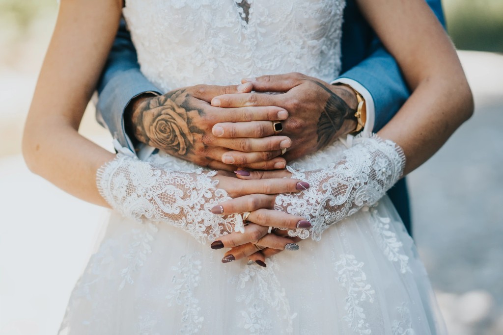 Swiss wedding photography close-up of bride and groom hands with elegant wedding rings in golden sunlight